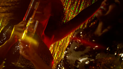 Close-Up-Of-Two-Women-Dancing-In-Nightclub-Bar-Or-Disco-Drinking-Alcohol-With-Sparkling-Lights-17